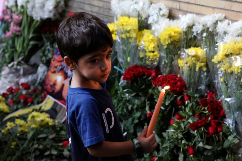 A young boy holds a candle in front of the Lebanese Embassy in Tehran, Iran, Wednesday, Sept. 18, 2024. (AP Photo/Vahid Salemi)