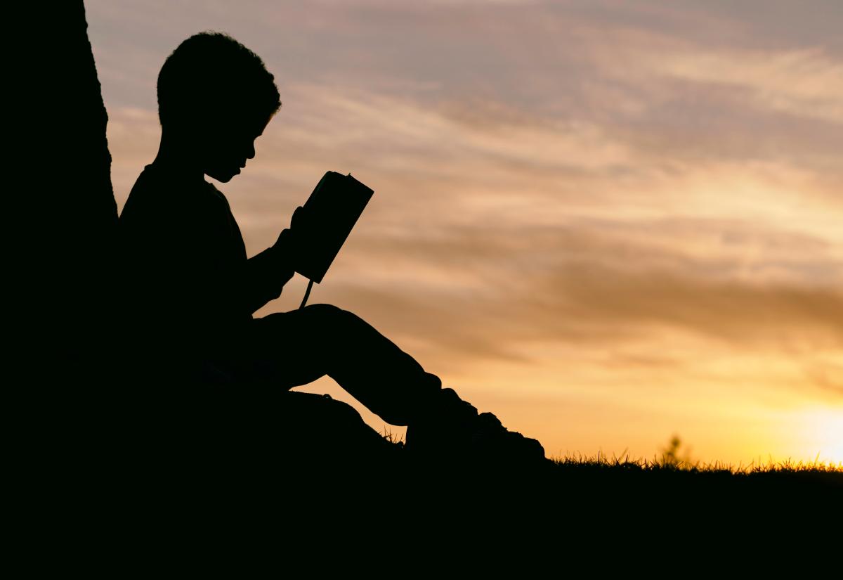 Child in silhouette reading