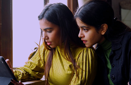 Two teen girls working on a tablet