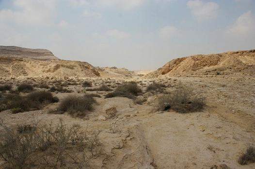 view of the dam from upstream in the middle of the valley. The ruins are visible on the 2 banks