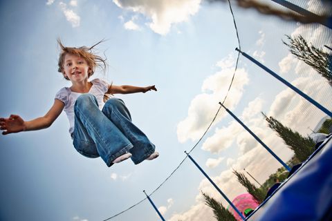 Ein kleines Mädchen springt auf einem Trampolin