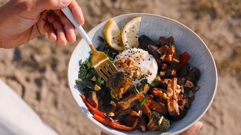 Schnelles Erdnuss-Curry mit Tofu  Für 2 Portionen  Zutaten:  1 Tasse Basmatireis, 2 Tassen Wasser, 2 Knoblauchzehen, 1 rote Zwiebel, 2 EL Rapsöl, 150 g Tofu, 2 EL Sojasauce, 1 Aubergine, klein geschnitten, 1 rote Paprika, klein geschnitten, 1⁄2 Brokkoli, klein geschnitten  Für die Sauce  1 TL Paprikapulver, geräuchert, 1⁄4 TL Chilipulver, 250 ml Hafer- oder Sojasahne ,1 EL Erdnussbutter, 1 1⁄2 cm frischer Ingwer, 2 TL Birnendicksaft (oder andere Süße), 2 EL Sojasauce  Zubereitung:  Den Reis nach Packungsanweisung im Wasser gar kochen. Den Knoblauch und die Zwiebel hacken und in einer großen Bratpfanne im Rapsöl anrösten. Den Tofu in mundgerechte Stücke schneiden und ebenfalls anbraten. Sobald er goldbraun ist, mit der Sojasauce ablöschen und das restliche Gemüse hinzufügen. Weitere 10 Minuten unter stetigem Umrühren in der Pfanne anbraten.  Im Standmixer oder mit dem Pürierstab die Zutaten für die Sauce mixen und zum Gemüse geben. Die Hitze reduzieren und alles 5 Minuten einköcheln lassen, bis die Sauce eindickt.  Den gegarten Reis in eine Tasse geben und festdrücken, auf einen Teller stürzen und mit dem Curry servieren. Als Toppings eignen sich frisch gehackte Kräuter wie Minze, Petersilie oder Koriander sowie gehackte Erdnüsse. Nach Wunsch mit einem Spritzer Zitronensaft abschmecken.