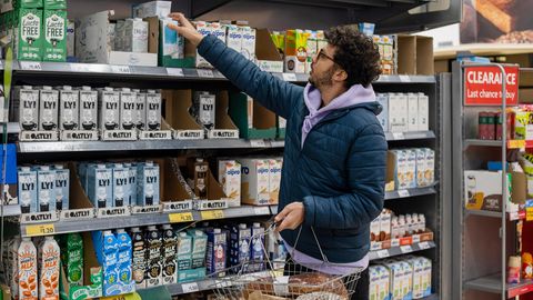 Mann im Supermarkt vor Pflanzendrinks