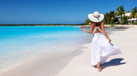 Frau am Strand in einem Kleid in der Nähe des Meeres