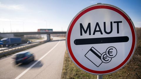 An einer Autobahn steht ein Hinweisschild, dass hier Maut anfällt