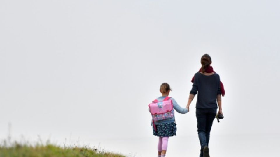 Frau mit Kind auf Weg zu Schule