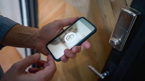 Ein Mann öffnet sein Smart Lock mit dem Smartphone