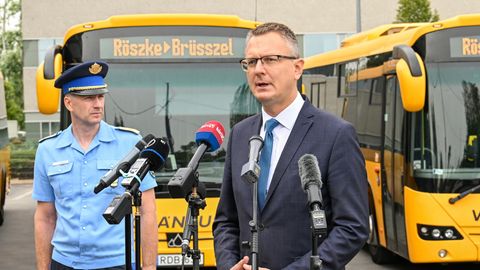 Ungarns Vize-Innenminister Bence Retvari steht vor Bussen "Röszke - Brüssel" steht