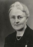 Portrait of a light haired woman with round glasses