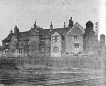 Railway in foreground, an old brick built building in the background