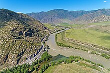 Photographie aérienne d'une vallée encaissée, avec en bas au premier plan la confluence de deux rivières. Le paysage est aride, la végétation se cantonnant aux rives.