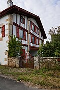 Vue d'une maison à deux étages aux pans de bois rouge.