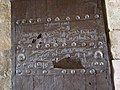 Arabic inscriptions on a brown, wooden door