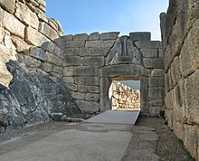 Porte en pierre, au fond d'une cour. Le linteau est surmonté d'une sculpture triangulaire, représentant deux lionnes prenant appui sur un double-autel surmonté d'une colonne.