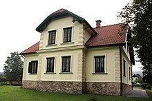 Casa onde Peter Rosegger viveu e faleceu, no centro. Casa de cor amarela com janelas escuras e uma chaminé