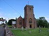 Red stone building with square tower.