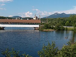 Covered bridge over the Upper Ammonoosuc River in front of former paper mill in Groveton. The Percy Peaks are in the distance.