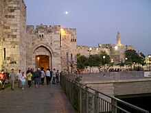 An archway and gate in a large stone wall