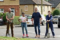 Hugh Dennis and archaeologists Tash, Richard and Chloe on a street with digging tools