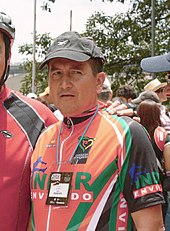 A man wearing a black cap in an orange top