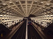 Train arriving at the McPherson Square metro station with a domed concrete ceiling