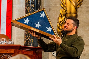 Zelenskyy receiving a United States flag from Nancy Pelosi and Vice President Kamala Harris