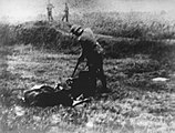 A German soldier points his rifle at a Serb lying on the ground in the village of Jajinci, which served as an execution site for inmates from the Banjica concentration camp