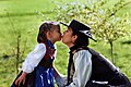 Bregenzerwälder Frauentracht. Mother kissing Daughteron the lips.