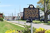 A black historical marker with yellow lettering