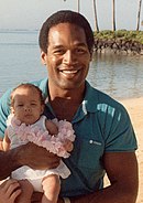 Un homme et une femme tenant un jeune enfant sur une plage paradisiaque.