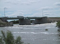 Betonové a kovové konstrukceA concrete and metal structure spans a section of choppy water