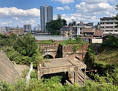 新逢坂山隧道東口の排煙設備跡（写真手前）と京阪京津線蝉丸跨線橋（写真奥）