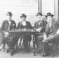 1898: Studentenschaakclub Alapin, Leiden. Van links naar rechts: ?, Emanuel Lasker (te gast bij de vereniging), Jan Esser (voorzitter vereniging), ?