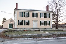 La taverne de Noah Brooks, bâtimpent de bois longeant une route.