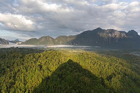 "Conical_shadow_of_Mount_Nam_Xay_over_green_trees_at_golden_hour,_South-West_view_from_the_top,_Vang_Vieng,_Laos.jpg" by User:Basile Morin