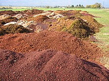 Photographie montrant un tas de marc de raisin en attente d'être distillé ; il peut aussi être composté et être utilisé pour faire un apport de matière organique.