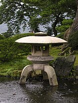 Lage staande Japanse lantaarn (Yukimi-dōrō) bij water