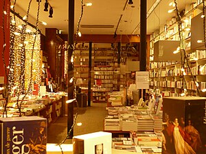 Vue du rayon littérature de la librairie pendant les fêtes, par une vitrine de la rue Vital-Carles.