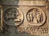 Round reliefs above right lateral archway, from south, over friezes