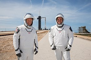 Gli astronauti della NASA Douglas Hurley (a sinistra) e Robert Behnken (a destra) con alle spalle il Falcon 9 con la navetta Crew Dragon installata in cima, sul Pad di Lancio 39A