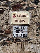 Bilingual street signs in Espolla, Spain, Spanish below and Catalan above.