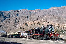 Train against mountains and a blue sky