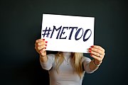 A woman holding a sign reading "#MeToo"