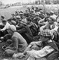 Serbian men and boys sitting in a field in the Stara Gradiška concentration camp, awaiting execution