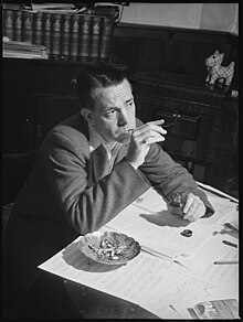 Black and white photo of a man focusing on writing sheet music.