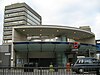 A grey building with a rectangular, dark blue sign reading "SOUTHWARK STATION" in white letters all under a light blue sky with white clouds