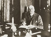 Photograph of a seated man with a monocle