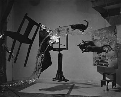 Portretfoto van Salvador Dali, insluitende voorwerpe, katte en water wat in surrealistiese bewegings gevang is, ca. 1948.