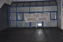 Drap accroché à la porte d'un bâtiment avec des inscriptions de mécontentement.