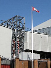 A white flagpole in front of football ground